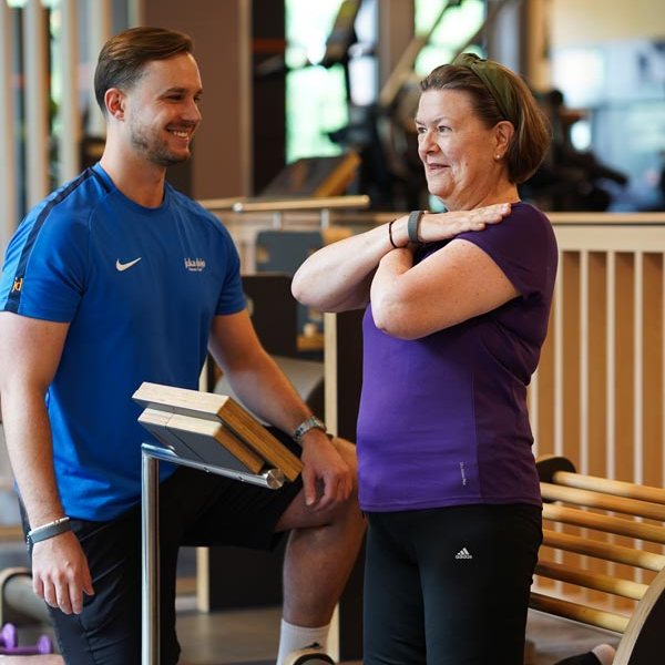 Trainer begleitet ein Mitglied an einem Trainingsgerät im juka dojo