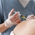 A clinician injects yellow regenerative cells into the upper back.