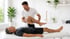 Male physiotherapist stretches a man's leg, stimulating cellular repair
