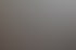 Drei lächelnde Kollegen sitzen bei einer Besprechung in einem hellen Büro an einem Tisch und blicken in die Kamera.
