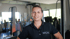 Eine Frau in einem schwarzen Poloshirt mit "MOVE" Logo steht in einem Fitnessstudio.
