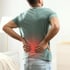 Man holding his lower back with a red highlight indicating pain.