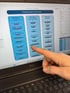 Finger tippt auf "Ursachenanalyse Unternehmen" auf einem Dell-Laptop, der Blockaden für Person, Unternehmen und Gebäude anzeigt.