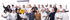 Eine große Gruppe von Männern und Frauen, einige halten Werkzeuge und ein gelbes Sto-Schild, auf grünem Hintergrund.