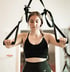 Junge Frau beim Training mit TRX-Sling-Trainer