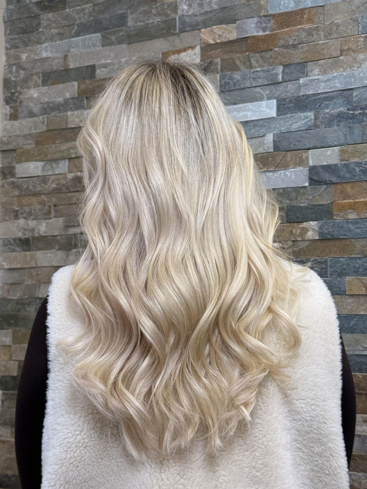 Lange, gewellte Echthaarextensions in Blond von hinten, Ergebnis von Escape-Beauty in Hannover