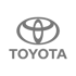 Graues Toyota-Logo mit stilisierten Ovalen und dem Wort "TOYOTA" auf dunkelgrünem Hintergrund.