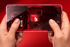 Zwei Hände halten ein rotes Smartphone mit transparentem Display, das den internen Chip und das leuchtende 'Snapdragon 8 Elite' Logo zeigt.