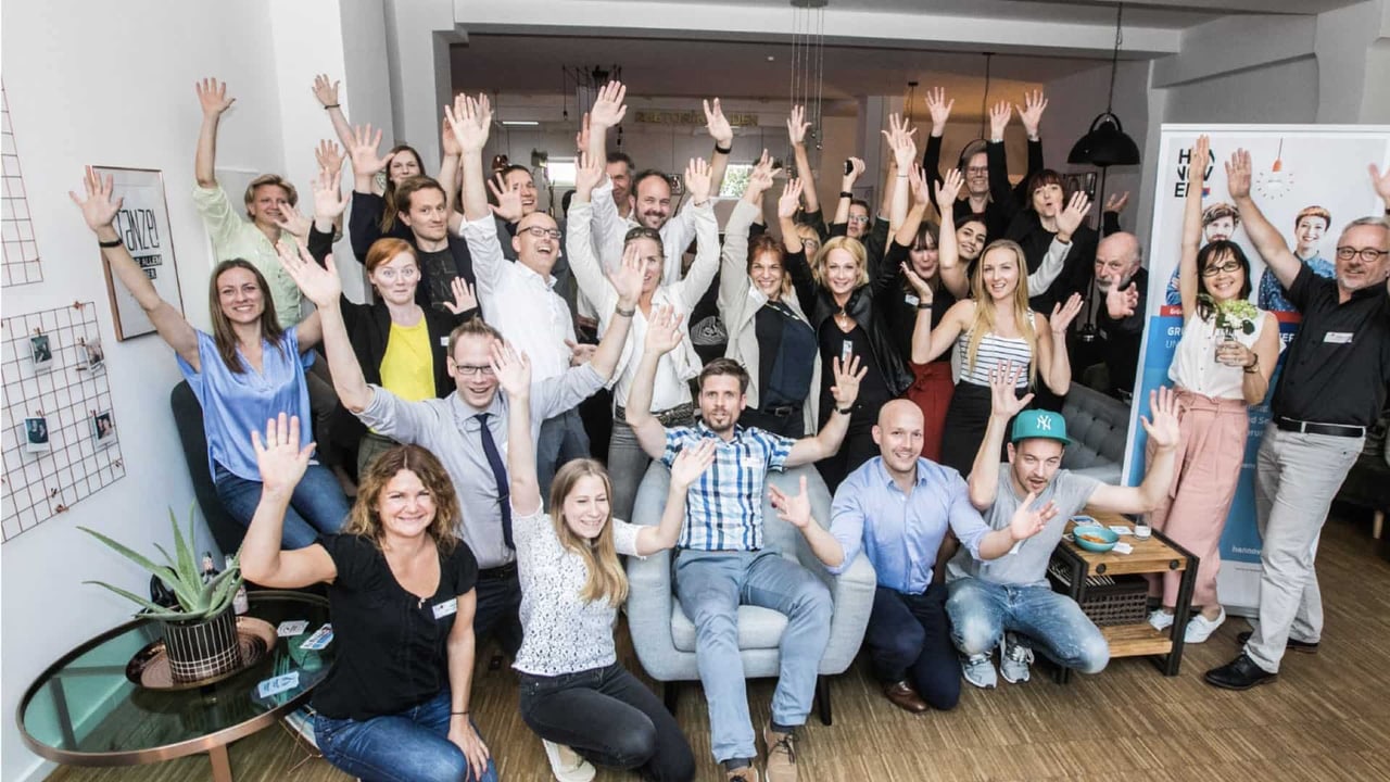 Gruppenfoto mit jubelnden Teilnehmenden einer NEOP-Veranstaltung