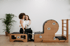 Eine Trainerin unterstützt eine Frau bei Übungen an einem hölzernen Pilates Reformer Gerät in einem hellen Studio.