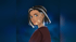 An animated woman with dark hair and white streaks looks over her shoulder, showing vitiligo patches on her face and neck.