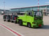 Förderung für elektrische Zugmaschinen am Flughafen: grüne Elektro-Zugmaschine mit Gepäckwagen auf dem Vorfeld