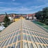Dachstuhl eines Hauses mit Holzbalken und Unterspannbahn, im Hintergrund eine Stadtlandschaft.