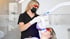 Zahnärztin führt bei einer Patientin mit Schutzbrille ein professionelles Bleaching mittels UV-Lampe durch.