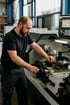 Ein Mann bedient eine Drehmaschine in einer Werkstatt.