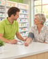 Apotheker misst einer Kundin am Tresen der Stadt-Apotheke den Blutdruck am Oberarm