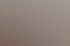 Drei lächelnde Personen, zwei Frauen und ein Mann, stehen in einem Büro mit Glaswänden.