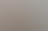 Eine ältere Frau und eine Pflegekraft sitzen sich in einem hellen Wohnzimmer an einem Tisch gegenüber und unterhalten sich.
