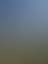 Gepflasterter Parkplatz zwischen modernen Wohnhäusern unter blauem Himmel bei Sonnenschein.