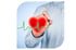 Hand hält leuchtendes rotes Herz mit grüner EKG-Linie, die Herzschlag anzeigt.