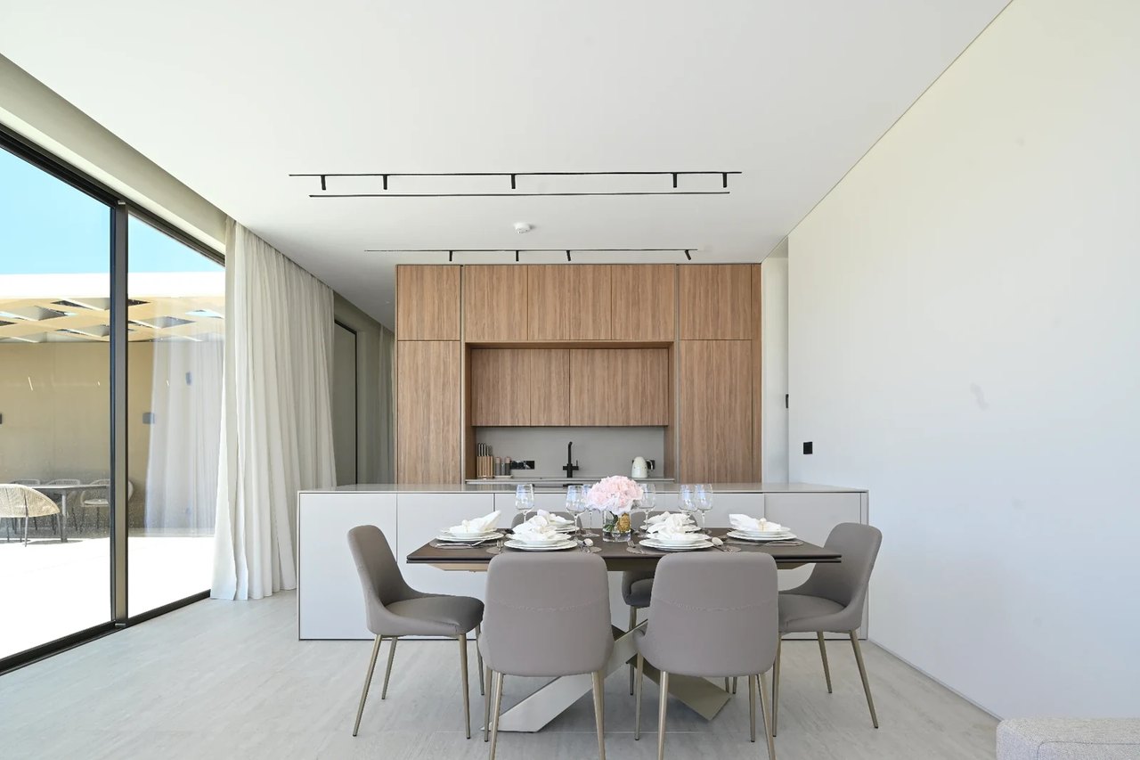 Helle Küche mit Esstisch und großer Glasfront zum Außenbereich.
