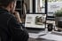 Handwerker betrachtet die Website eines Handwerksbetriebs am Laptop