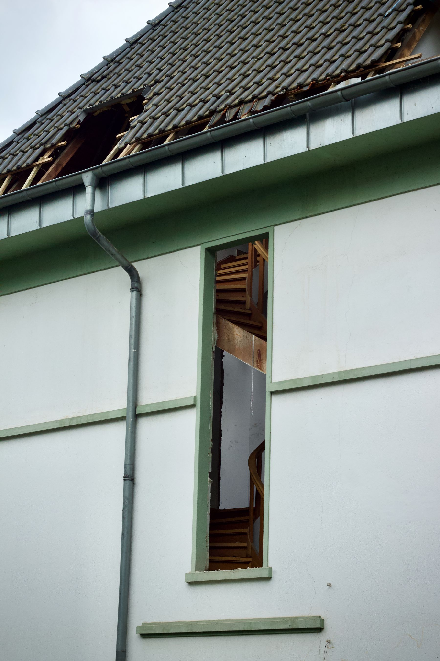 House with a broken roof and exposed structure after a severe storm