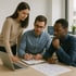 Three diverse colleagues collaborate at a table, reviewing a flowchart diagram, with a laptop and pen.