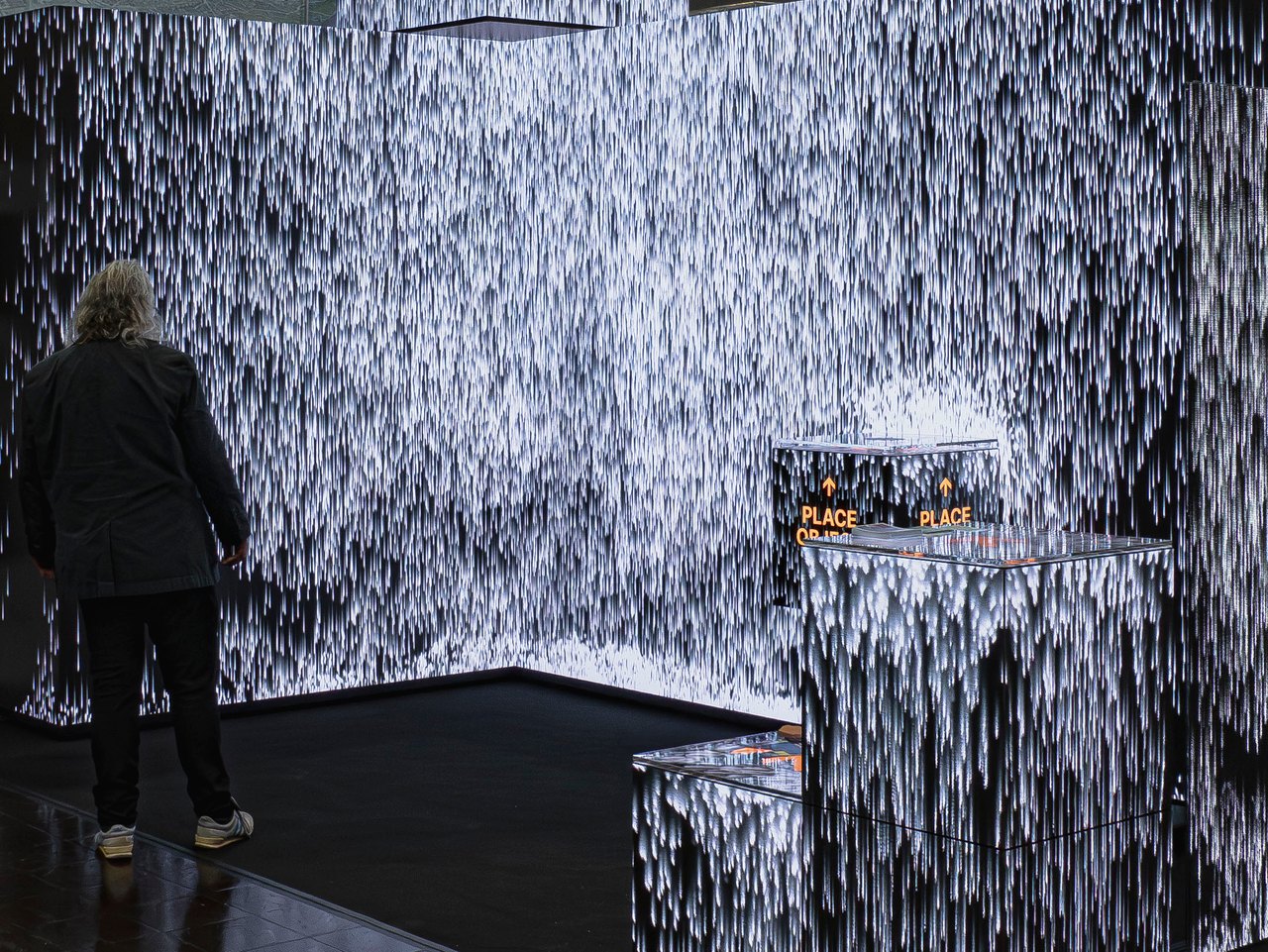 Immersive Rauminstallation: Ein 360°-LED-Wasserfall hüllt Besucher vollständig ein – weiche Weiß-Partikel rieseln die Wände entlang und verwandeln den Raum in ein atmosphärisches Gesamterlebnis