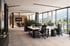 Modernes Großraumbüro mit ergonomischen Arbeitsplätzen, Glasfront, Bergblick und angrenzendem Konferenzraum.