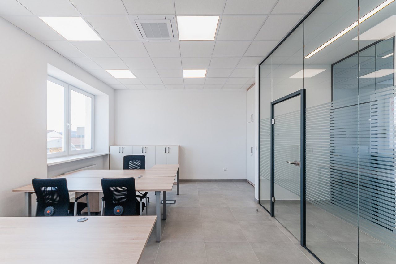 Modernes Büro mit Deckenabhängung, Lichtfeldern und Glaswänden