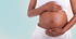 Eine schwangere Frau mit dunkler Haut hält ihren runden Babybauch mit beiden Händen.