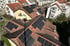 Dächer mit schwarzen Solarpanels und einem Storchennest auf einem Schornstein.