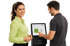 Ein Mann bedient ein digitales Zeiterfassungsterminal per Touchscreen, während eine lächelnde Frau daneben steht.