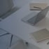 Laptop, Notizbücher und Stifte auf einem weißen Schreibtisch.