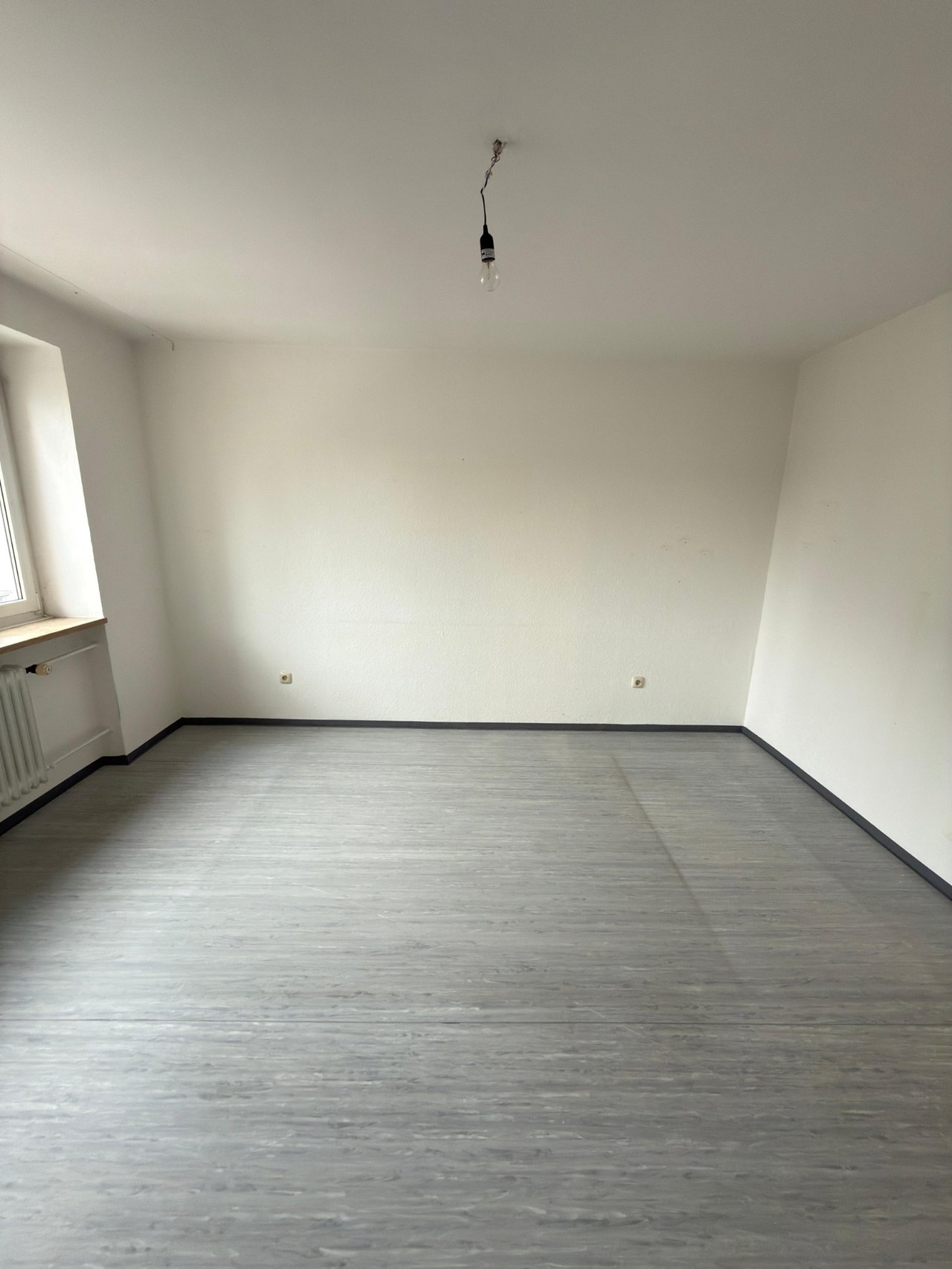 Leeres Wohnzimmer nach der Räumung einer stark belasteten Wohnung