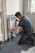 Installateur richtet bei einer Badsanierung ein Vorwandelement für ein Unterputz-WC mit der Wasserwaage aus