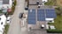 Dach eines Hauses mit installierten Solarmodulen, daneben ein Auto auf der Straße.