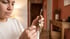 A woman in a white sweater looks down while holding a keychain with several metal keys in a home hallway.