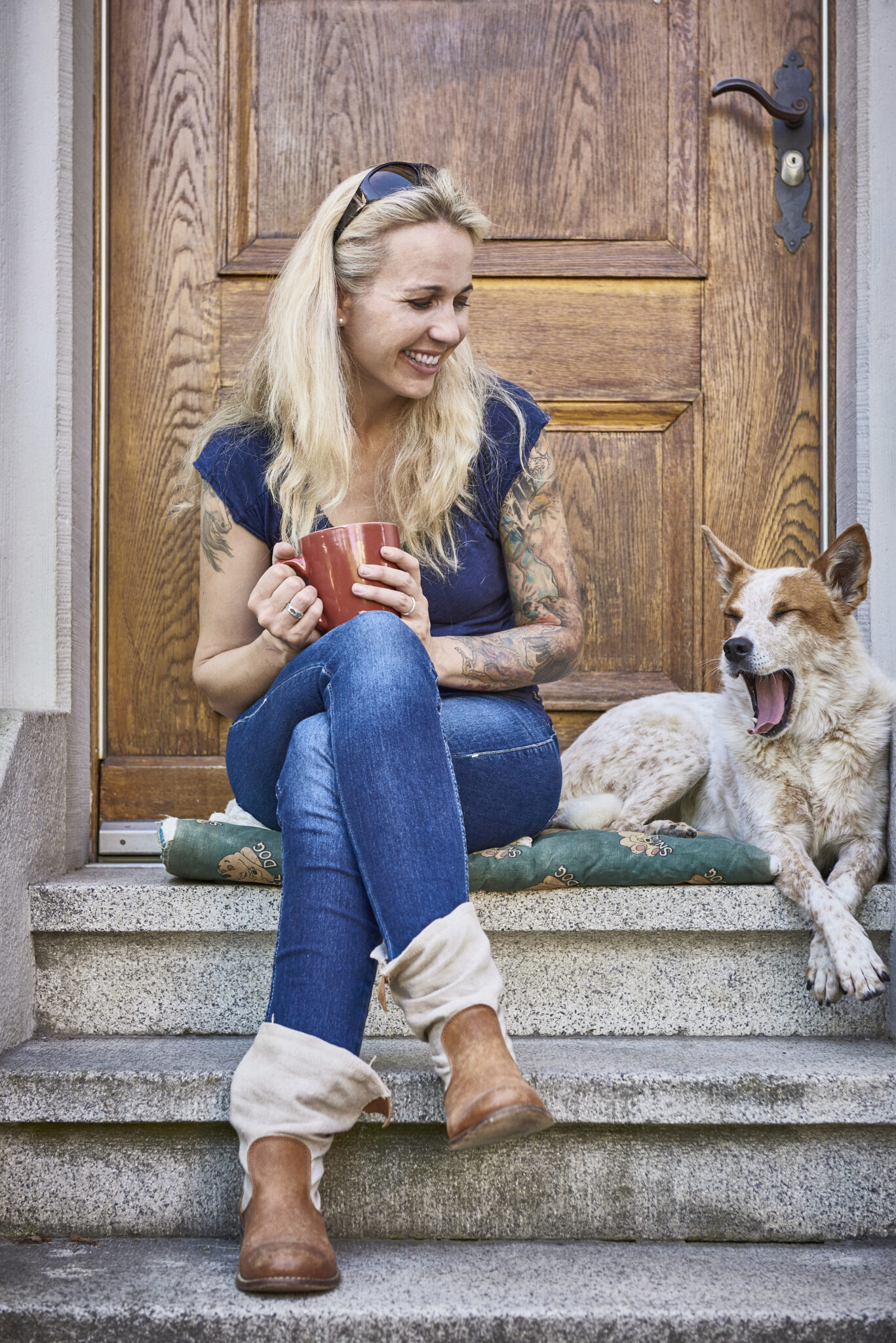 Virginia Fox mit Cattledog Paige auf einer Treppe vor Eingangstür. Photo Credit: R. Ruis
