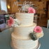 Dreistöckige Hochzeitstorte mit weißem Zuckerguss, pinken Gerbera, weißen Rosen und dem Schriftzug "Marie Kristin & Alex".