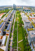 Luftaufnahme der Parkstadt Schwabing in München mit modernen Bürogebäuden, Grünanlagen und den Highlight Towers im Hintergrund.