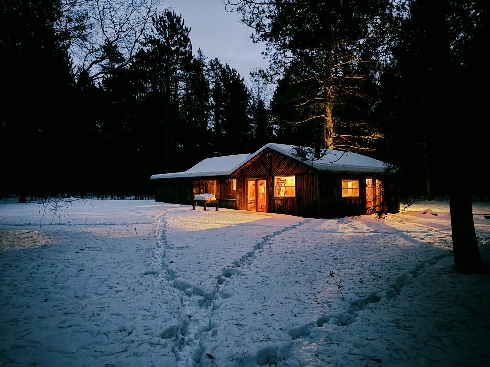 Maison chaleureuse en hiver, fenêtres illuminées