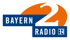 Logo Bayern 2 Radio, blauer Hintergrund mit weißer Schrift "BAYERN", orangefarbener Hintergrund mit großer weißer "2".