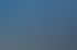Außenansicht einer DEKRA Prüfstelle mit großem Werbeschild, Werkstatthallen und Einfahrt unter blauem Himmel.
