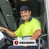 Lächelnder LKW-Fahrer in gelber Warnweste am Lenkrad mit dem Logo der Firma Unglehrt.