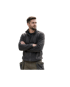 Ein Mann in einer grauen Fleecejacke und Arbeitshose mit verschränkten Armen blickt nach rechts.