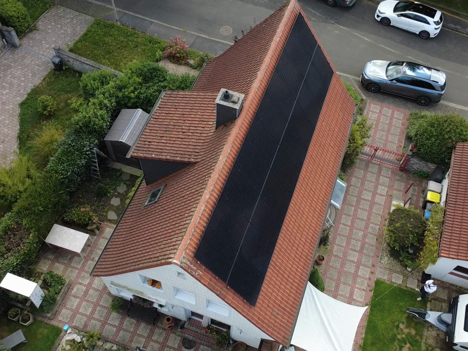 Einfamilienhaus mit schwarzen Modulen auf rotem Ziegeldach
