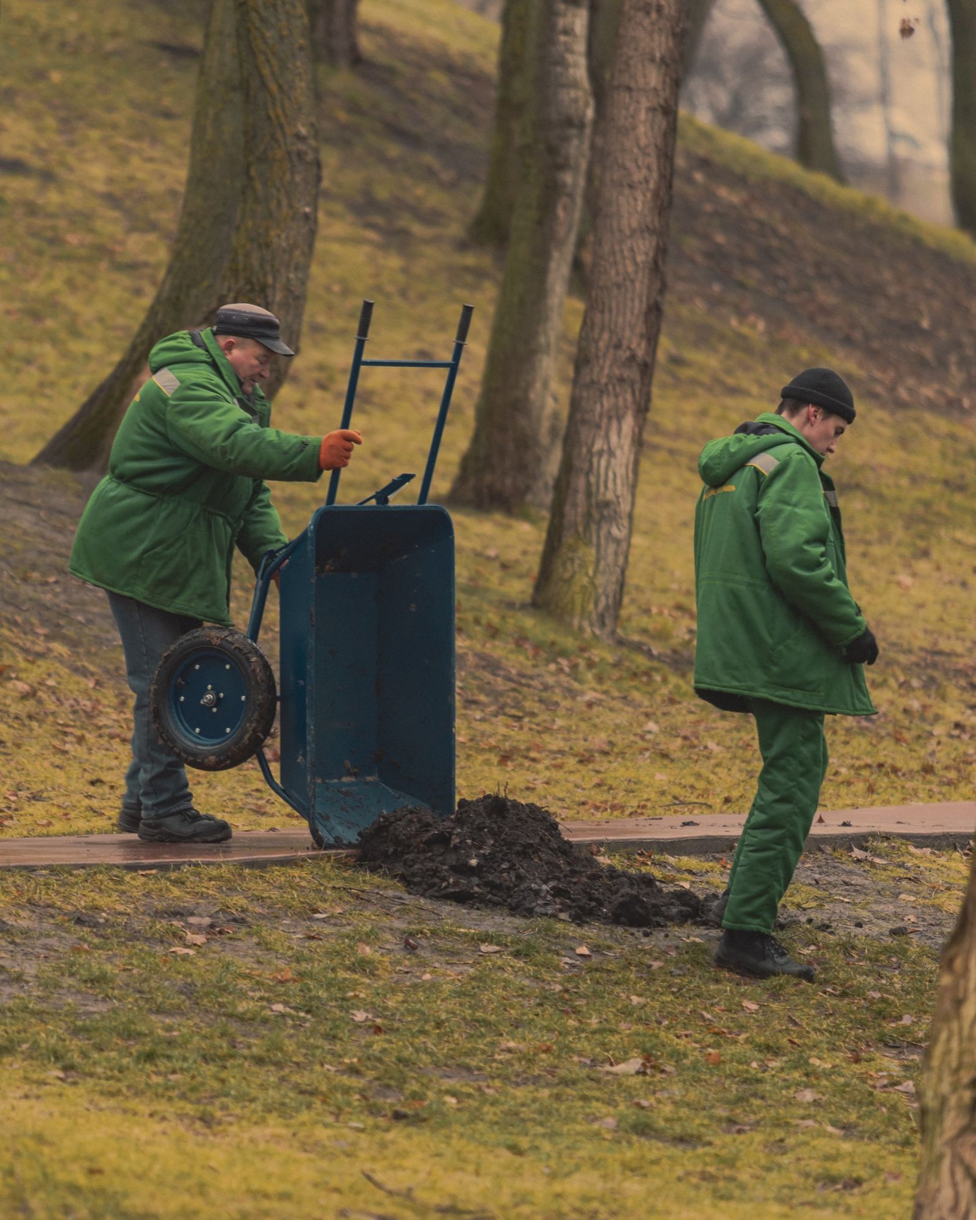 Zwei Gärtner mit Schubkarre bei der Parkpflege