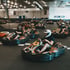 Menschen in Go-Karts auf einer Indoor-Rennstrecke.